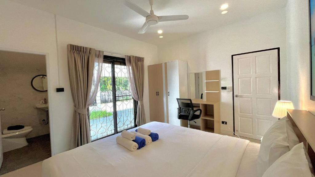 a bedroom with a white bed with a ceiling fan at Baiyok Villas near Kathu Waterfall in Ban Huai Luk (1)