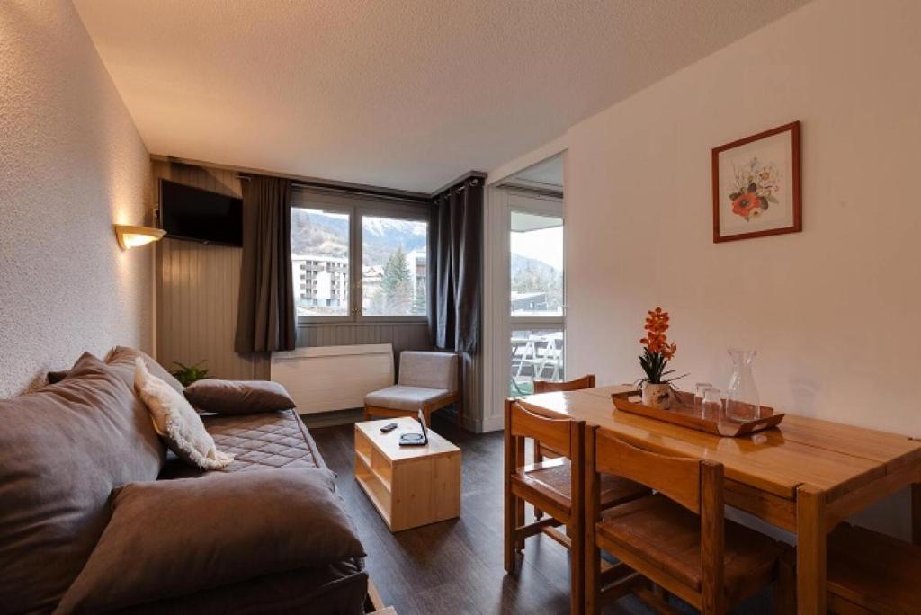a living room with a couch and a table at Résidence Les Melezes - Studio rénové · Accès pistes par navette · Parking extérieur MAE-0684 in Champcella