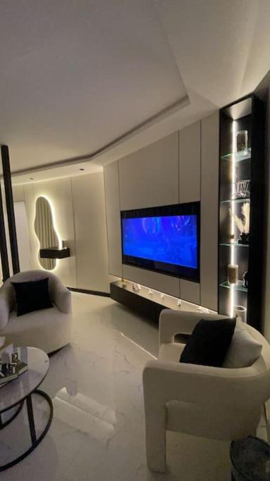 a living room with white furniture and a flat screen tv at Modern studio Self entry in Riyadh
