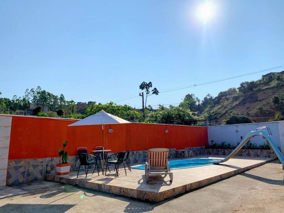 a patio with a table and chairs next to a swimming pool at Casa de campo Maria&Maria próximo a cidade de Juiz de Fora MG in Juiz de Fora