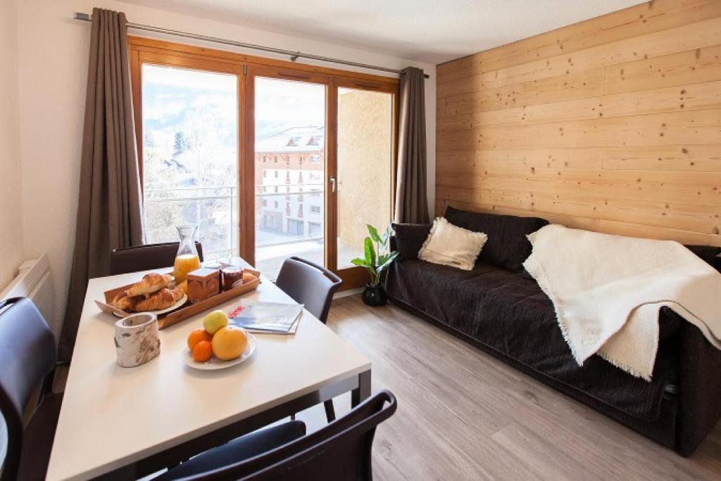 - un salon avec un canapé et une table avec des fruits dans l'établissement Résidence Signal Du Prorel - Agréable studio · Proche des pistes · Coin montagne & wifi gratuit MAE-0874, à Briançon