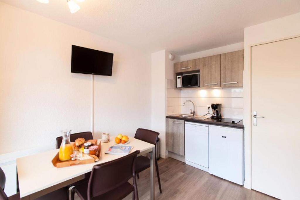 une cuisine et une salle à manger avec une table et des chaises dans l'établissement Résidence Signal Du Prorel - Studio tout confort · Accès direct aux pistes · Coin montagne & wifi gratuit MAE-0924, à Briançon