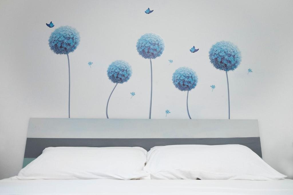 a bedroom with blue dandelions on the wall at Appartamento al mare civico28 in Porto Recanati