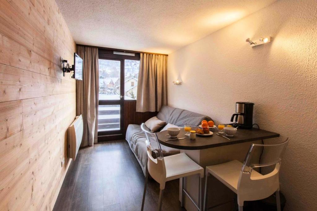 a living room with a couch and a table in a room at Résidence Les Melezes - Studio rénové & chaleureux · Accès pistes par navettes · Parking extérieur MAE-1104 in Champcella