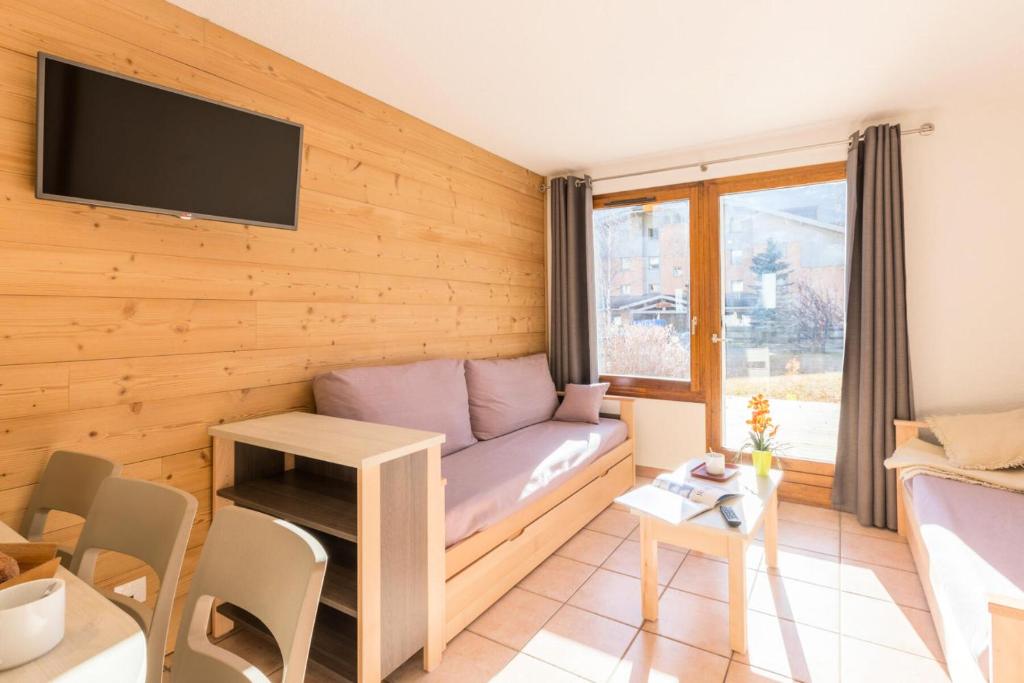 un salon avec un canapé et une table dans l'établissement Chalets Jardin Alpin - Chalet mitoyen duplex lumineux · Accès pistes par navette · Wifi gratuit · vue dégagée MAE-4794, à La Salle Les Alpes