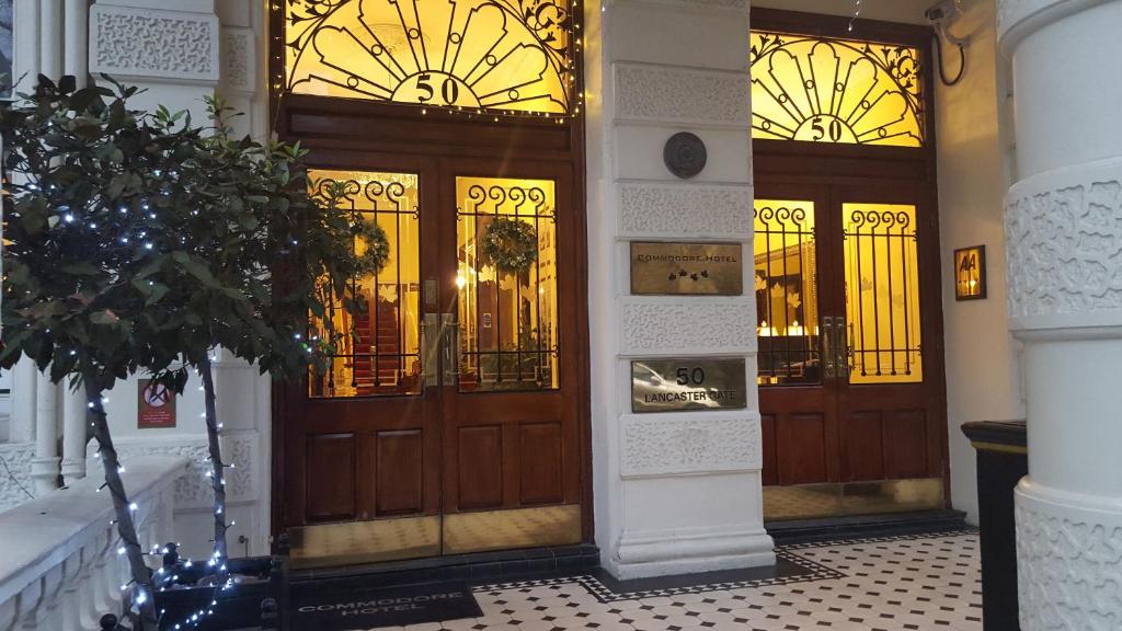 a large wooden door in a building with stained glass at Commodore Hotel in London