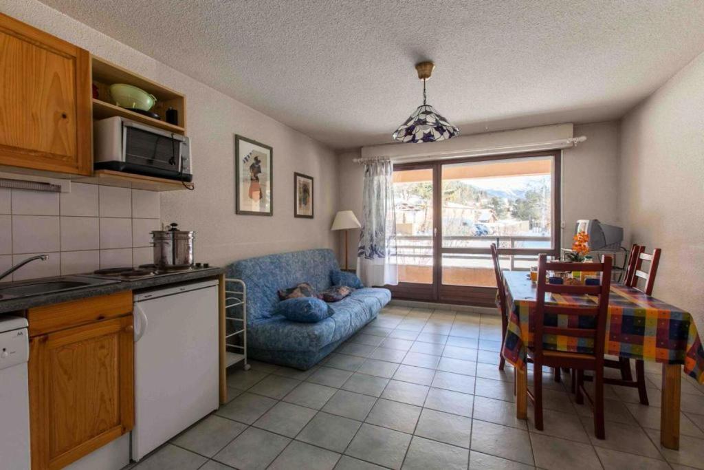 une cuisine et un salon avec un canapé et une table dans l'établissement Résidence Jardin Alpin Edelweiss - Studio confortable · Accès pistes par navette · Casier à skis privatif MAE-5064, à La Salle Les Alpes