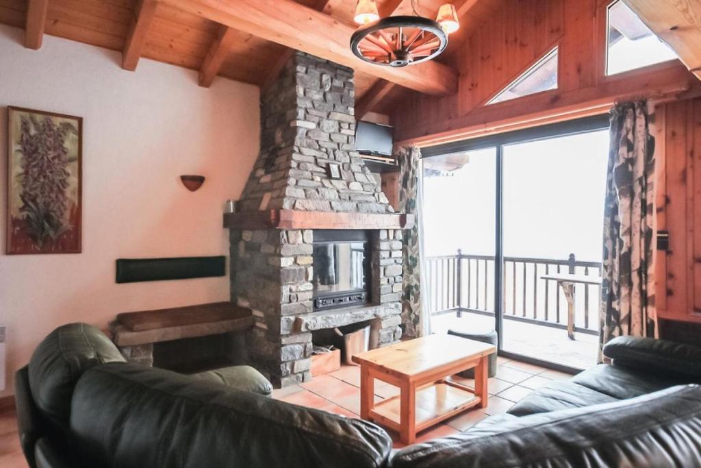 a living room with a fireplace and a leather couch at Chalet Digitale - Appartement en Chalet 10 personnes MAE-8234 in Montvalezan