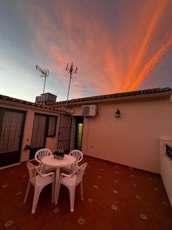 a table and chairs on a patio with a sky at Alojamiento el camarín in Baños de la Encina