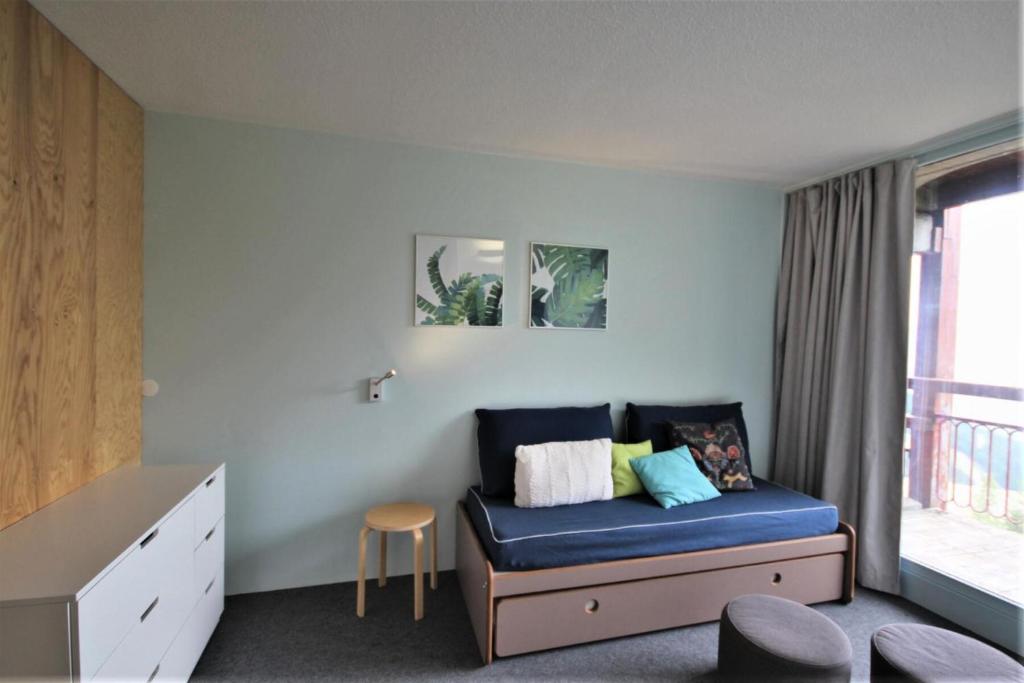 ein kleines Zimmer mit einem blauen Sofa und einem Fenster in der Unterkunft Résidence Varet 2 - Appartement rénové 3 pièces 7 personnes MAE-7854 in Arc 2000