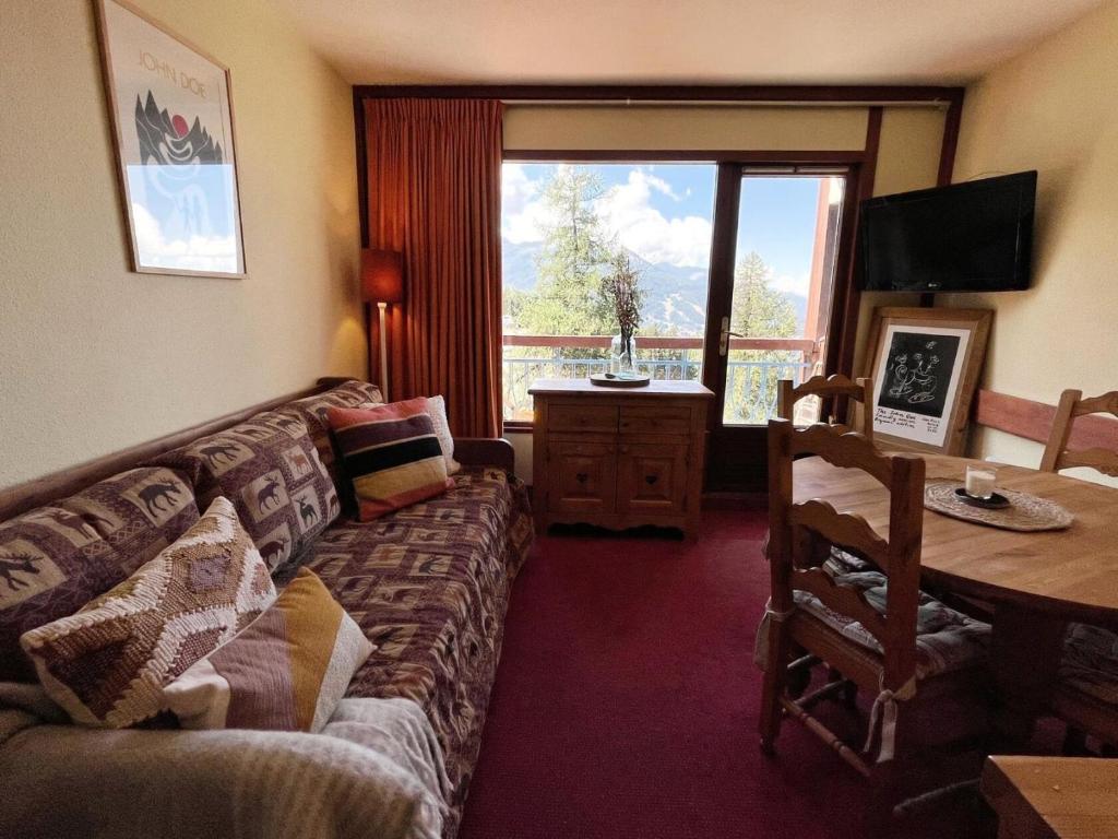 un salon avec un canapé, une table et une fenêtre dans l'établissement Résidence Ruitor - Deux pièces 4 personnes MAE-1904, à Arc 1800