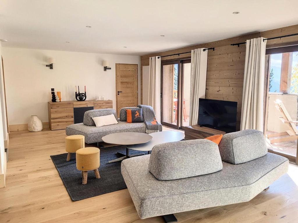 un salon avec deux canapés et une télévision dans l'établissement Résidence Diamant Des Cimes - Appartement Haute Gamme avec vue sur la vallée MAE-3264, à Montvalezan