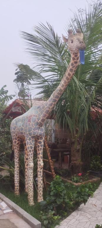 a statue of a giraffe with a drink in its mouth at Cantinho da Gigi in Peruíbe