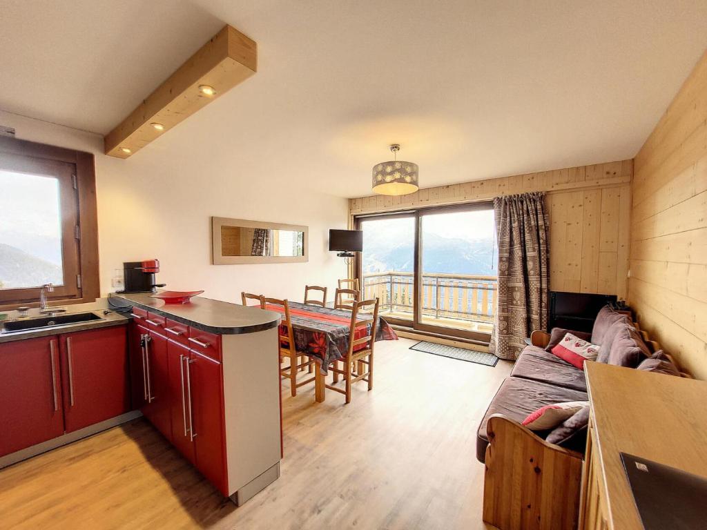 une cuisine et un salon avec un canapé et une table dans l'établissement Résidence Les Alpages - Appartement chaleureux et lumineux · Centre station · Balcon MAE-5374, à Montvalezan