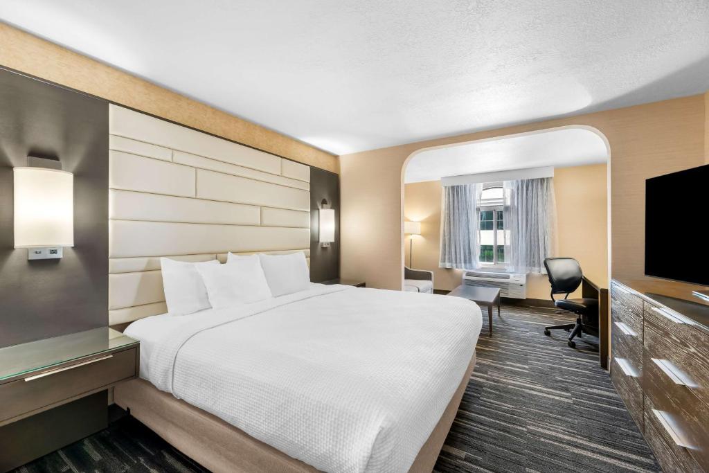 a hotel room with a bed and a flat screen tv at Best Western Plus Abbey Inn in St. George