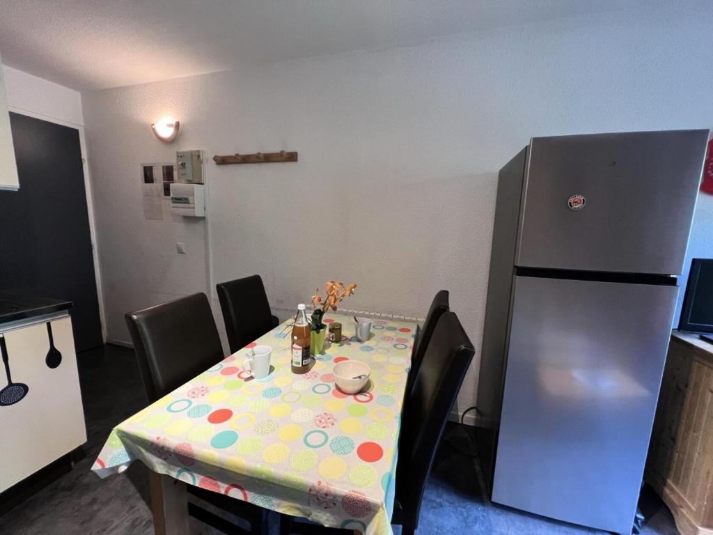 d'une table avec un chiffon de point polka et d'un réfrigérateur. dans l'établissement Résidence Grand Sud - Studio · Proche commerces MAE-4044, à La Salle Les Alpes
