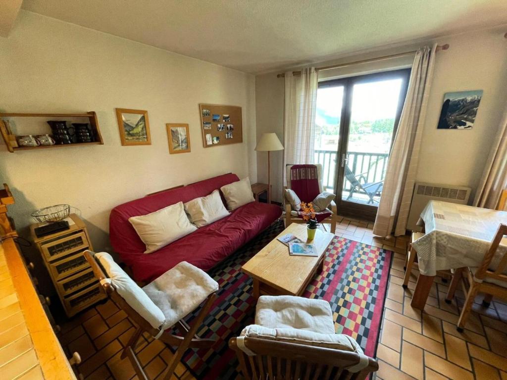un salon avec un canapé rouge et une table dans l'établissement Résidence Gardiole 4 - Appartement chaleureux · Centre village · Cheminée MAE-1614, au Monêtier-les-Bains