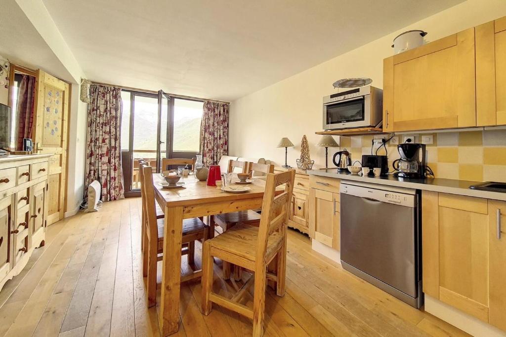 une cuisine avec une table en bois et une salle à manger dans l'établissement Résidence Burons - Appartement · Balcon sud MAE-9684, aux Menuires