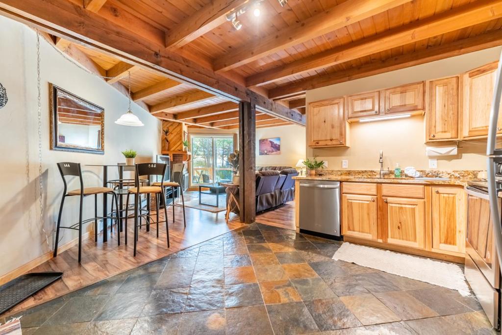 a kitchen with wooden cabinets and a dining room at Treehouse #107, Building G by Summit Country Mountain Retreats in Silverthorne