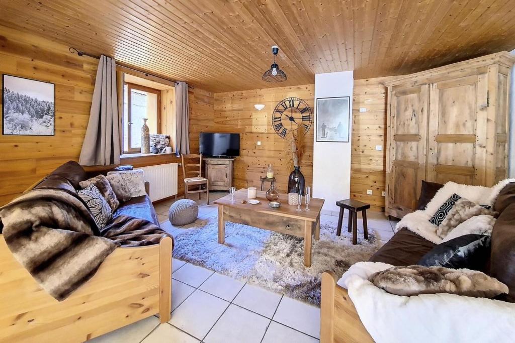 ein Wohnzimmer mit Sofa und Tisch in der Unterkunft Résidence Les Granges - Chalet spacieux · Centre village des Granges · Sauna MAE-0184 in Saint-Marcel