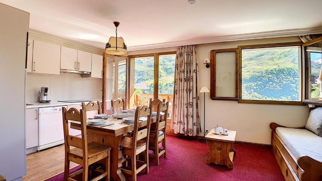 eine Küche und ein Esszimmer mit Tisch und Stühlen in der Unterkunft Résidence Les Cristaux - Appartement rénové · Proche des pistes · Balcon · Sauna · Hammam · WIFI MAE-0304 in Levassaix