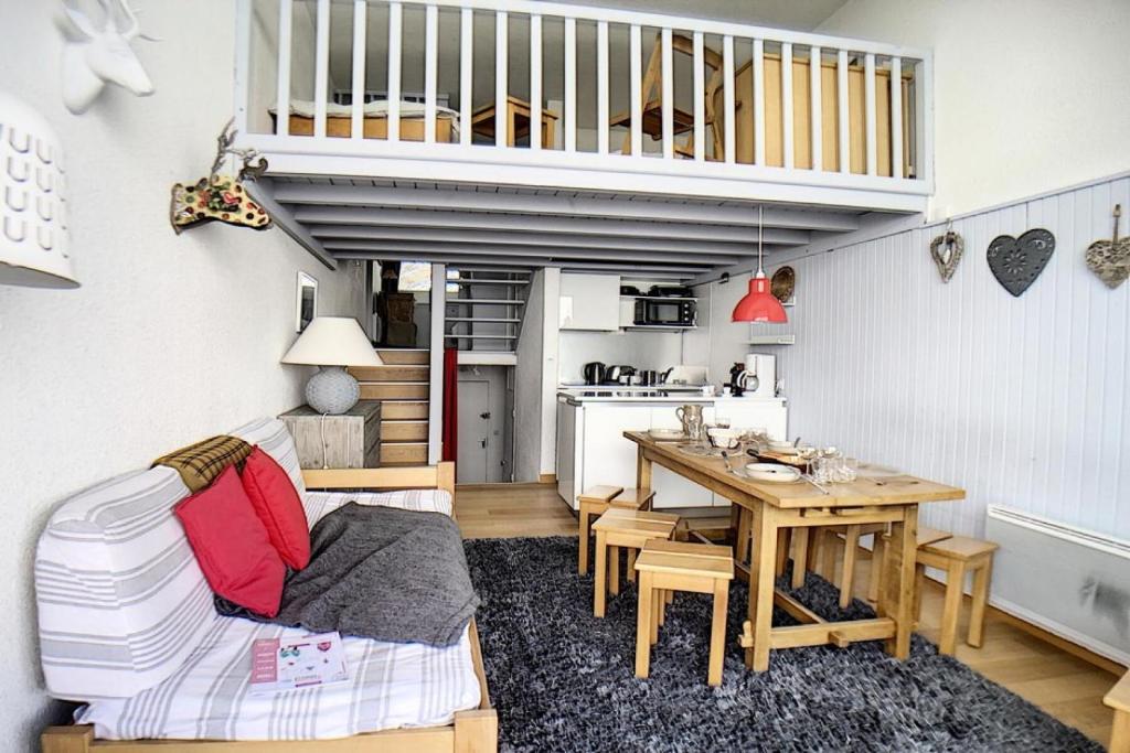 Il comprend un petit salon avec une table et une cuisine. dans l'établissement Résidence Danchet - Appartement duplex moderne · Ski aux pieds · Balcon MAE-0714, aux Menuires