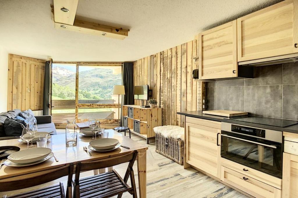 une cuisine avec une table et une salle à manger dans l'établissement Résidence Caron - Bel appartement entièrement rénové en 2016 MAE-0784, aux Menuires