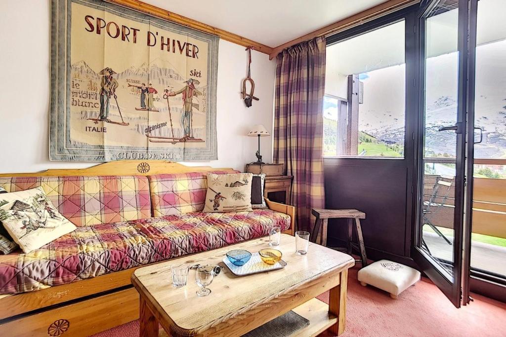 un salon avec un canapé et une table dans l'établissement Résidence Burons - Appartement lumineux · Proche des remontées mécaniques · Balcon MAE-0864, aux Menuires