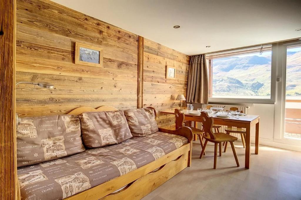 - un salon avec un canapé et une table à manger dans l'établissement Résidence Les Lauzes - Appartement duplex confortable · Au pied des pistes · Balcon MAE-0944, aux Menuires