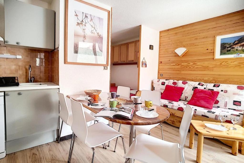 une cuisine et une salle à manger avec une table et des chaises dans l'établissement Résidence Ski Soleil - Appartement lumineux · Départ ski aux pieds · Terrasse MAE-1054, aux Menuires