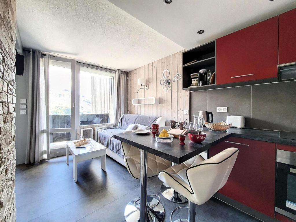 une cuisine et un salon avec une table et un canapé dans l'établissement Résidence Villaret - Appartement rénové et moderne · Au pied des pistes · Balcon MAE-1224, aux Menuires