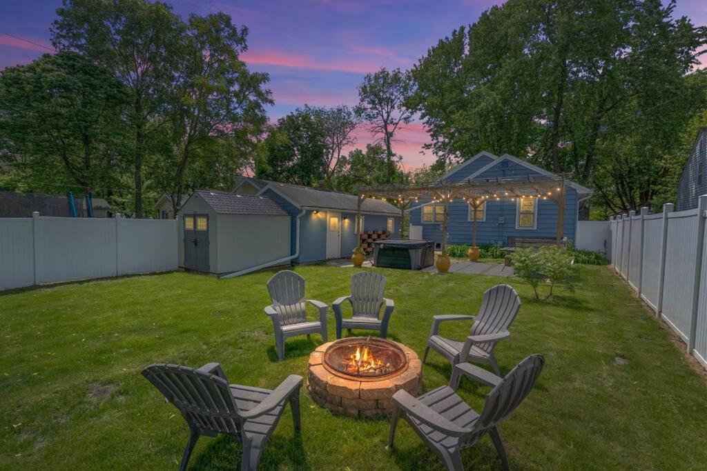 un cortile con sedie e un focolare nell'erba di The Hideaway on Hazel- Luxury Smart Home w Hot Tub ad Ames