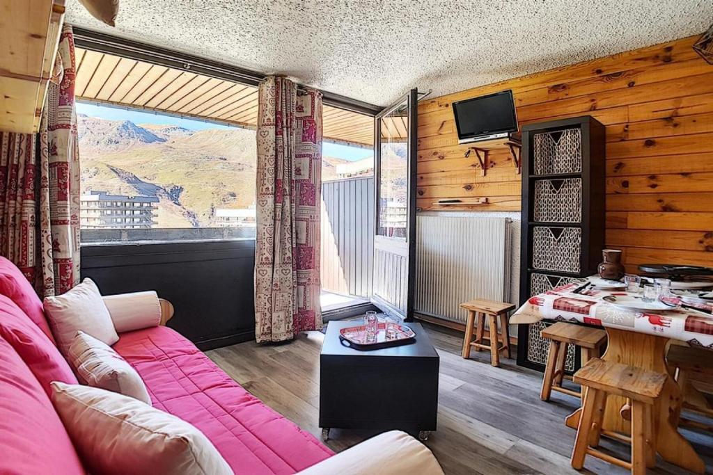 un salon avec un canapé rose et une table dans l'établissement Résidence Aravis - Studio entièrement rénové · Centre station · Balcon MAE-1244, aux Menuires