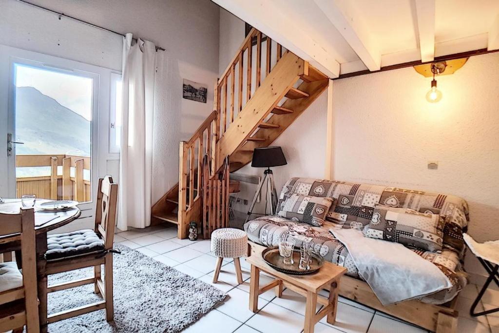 - une chambre avec un lit et un escalier en bois dans l'établissement Résidence Carlines Ii - Appartement duplex · Accès direct aux pistes · Balcon MAE-1384, aux Menuires