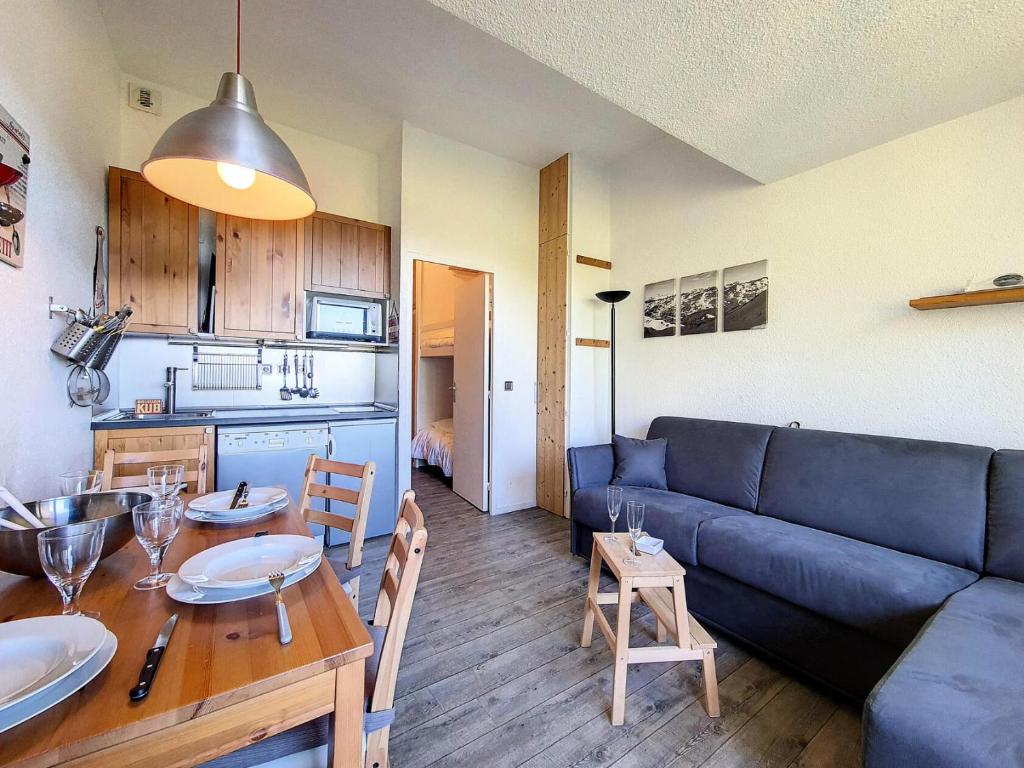 un salon avec un canapé bleu et une table dans l'établissement Résidence Boedette A - Appartement rénové · Au pieds des pistes · Balcon vue montagnes MAE-1424, aux Menuires