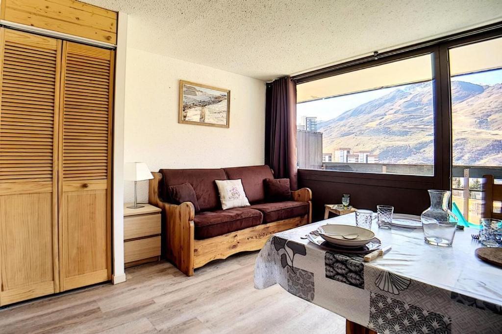 un salon avec un canapé et une table dans l'établissement Résidence Aravis - Studio confortable · Accès direct aux pistes · Balcon MAE-1494, aux Menuires