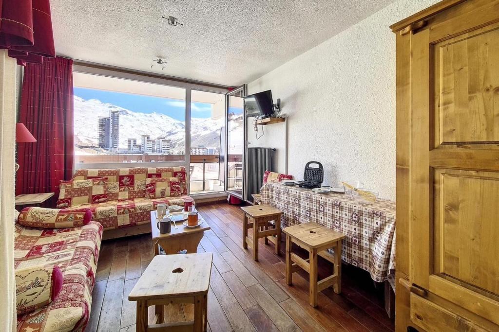 une chambre avec des canapés et des tables ainsi qu'une grande fenêtre dans l'établissement Résidence Chaviere - Studio lumineux · Ski aux pieds · Balcon sud MAE-1544, aux Menuires