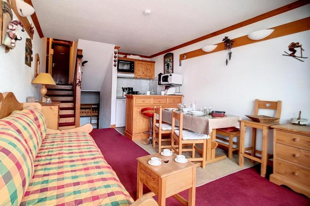 un salon avec un canapé et une table et une cuisine dans l'établissement Résidence Cote Brune - Studio duplex lumineux · Départ et retour ski aux pieds · Balcon MAE-1704, aux Menuires