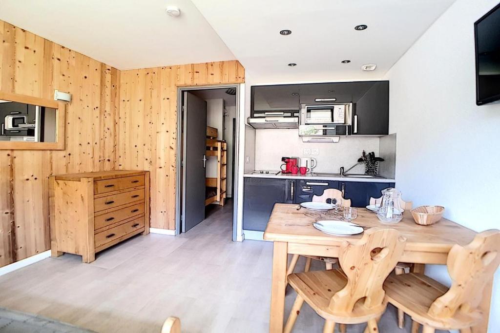 - une cuisine avec une table et des chaises en bois dans l'établissement Résidence Median - Studio rénové · Proche des pistes · Balcon MAE-1754, aux Menuires