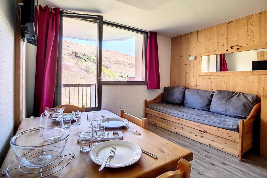 une salle à manger avec une table et un canapé dans l'établissement Résidence Median - Studio pour 3 Personnes 864, aux Menuires