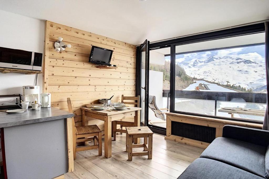 Il comprend une cuisine et un salon offrant une vue sur la montagne. dans l'établissement Résidence Dorons - Studio rénové · Centre station · Balcon MAE-1904, aux Menuires