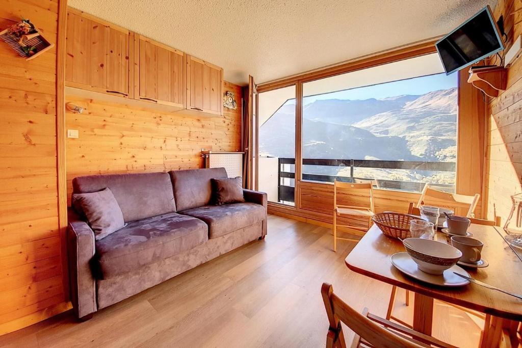 un salon avec un canapé et une table dans l'établissement Résidence Chaviere - Studio agréable · Ski aux pieds · Balcon MAE-1914, aux Menuires