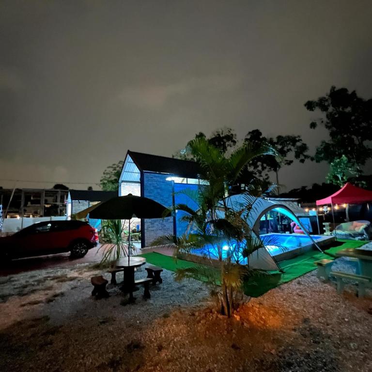 a blue building with a table and an umbrella at The Lil Luxe Tiny Homes Bangi - 2 Villa with 2 Private Pools in Bandar Baru Bangi