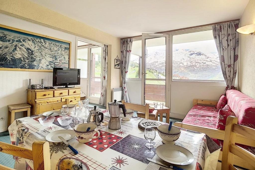 - un salon avec une table à manger et un canapé dans l'établissement Résidence Burons - Appartement spacieux · Ski aux pieds · Balcon MAE-2154, aux Menuires