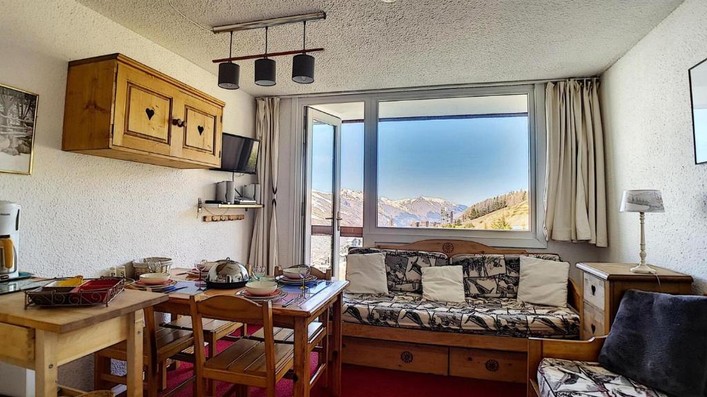 un salon avec un canapé et une table dans l'établissement Résidence Boedette A - Appartement duplex · Départ et retour skis aux pieds · Balcon vue montagne MAE-2244, aux Menuires