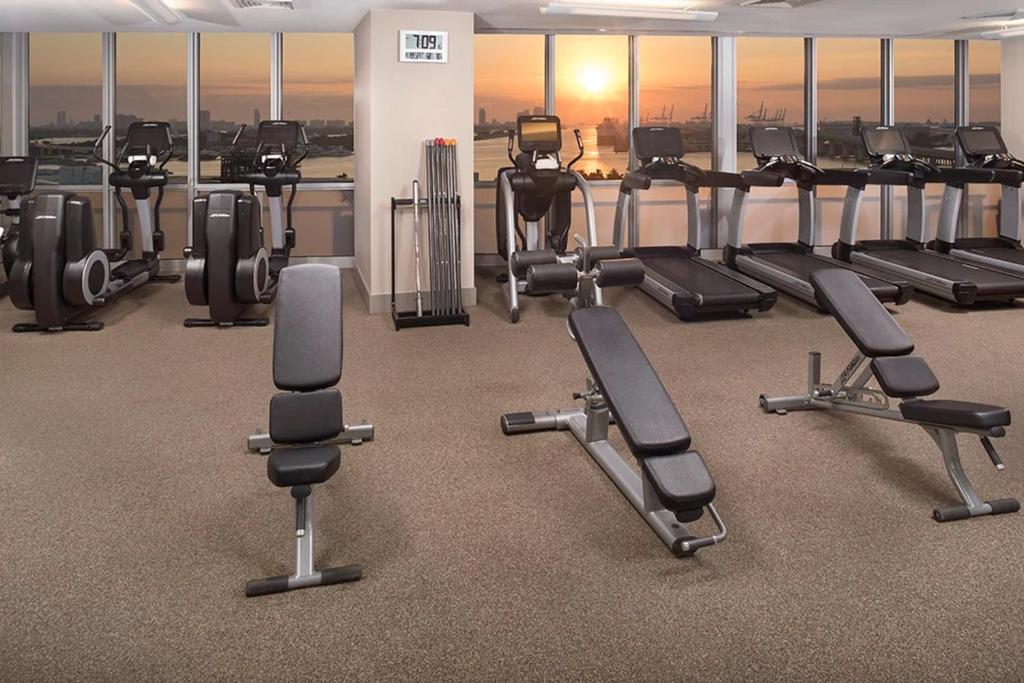 ein Fitnessstudio mit einem Haufen Laufbänder und Heimtrainern in der Unterkunft The Grayson Hotel Miami Downtown in Miami