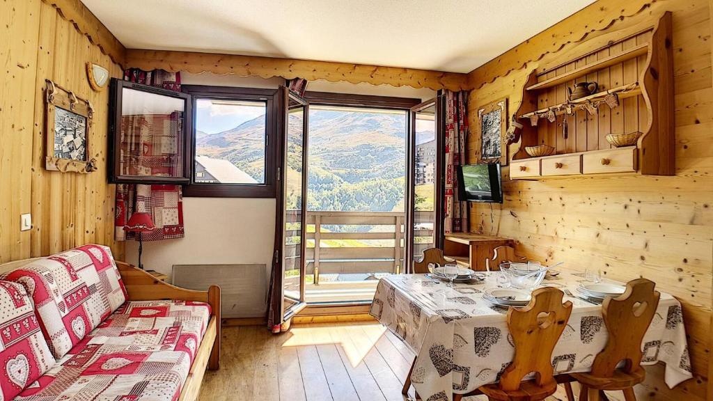 un salon avec une table et une grande fenêtre dans l'établissement Résidence Balcons D'olympie - Appartement agréable et lumineux · Au pied des pistes · Balcon MAE-2354, aux Menuires