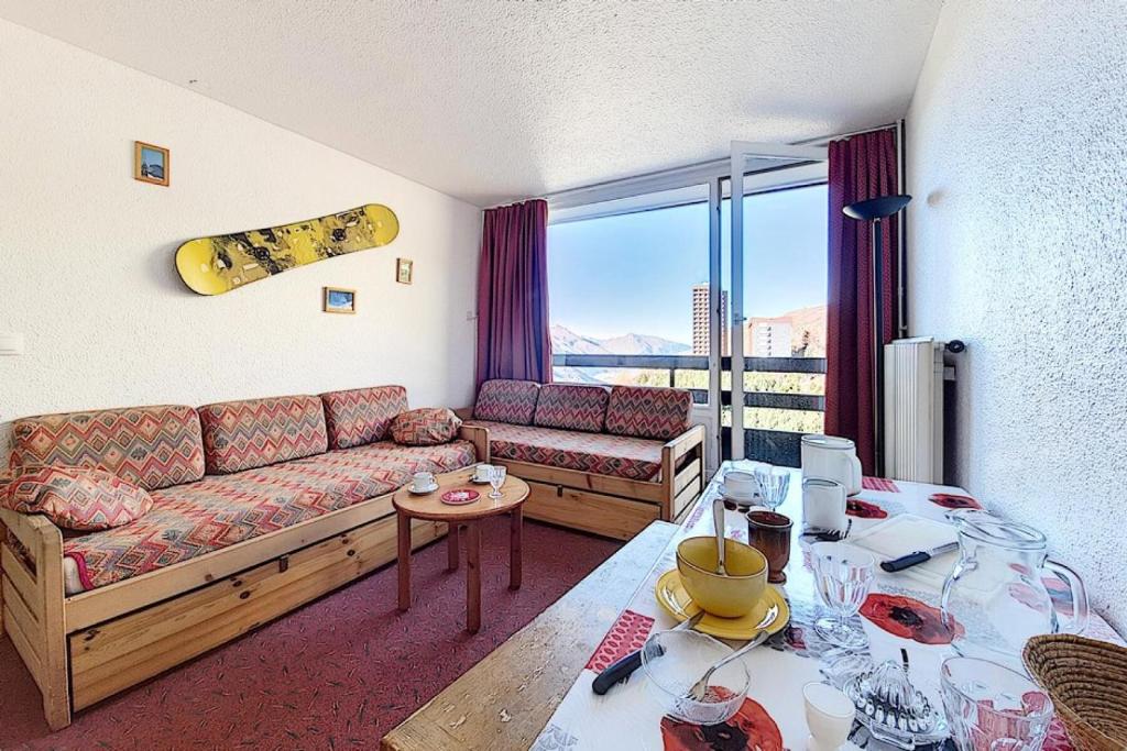 - un salon avec un canapé et un snowboard sur le mur dans l'établissement Résidence Chaviere - Appartement agréable · Au pieds des pistes · Balcon MAE-2384, aux Menuires