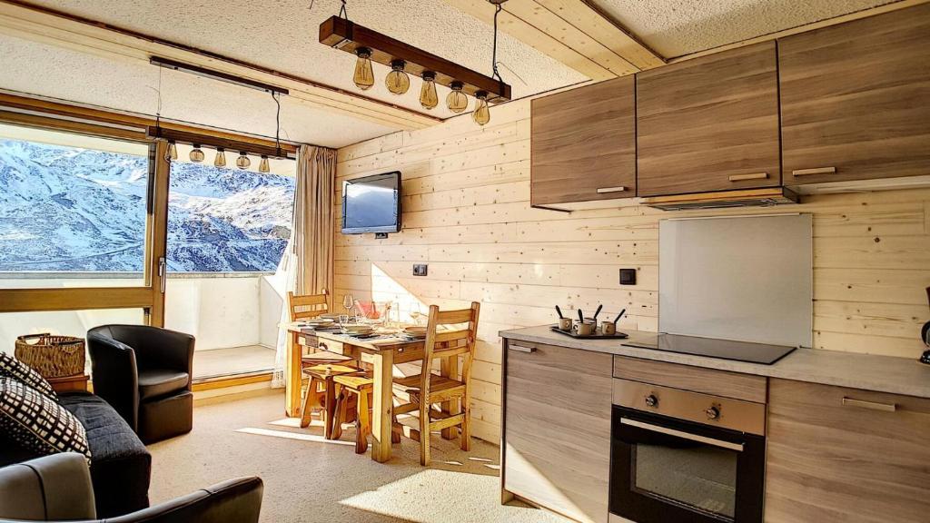une cuisine et une salle à manger avec une table dans une pièce dans l'établissement Résidence Evons - Studio rénové · Au pied des pistes · Balcon · Wifi MAE-2464, aux Menuires