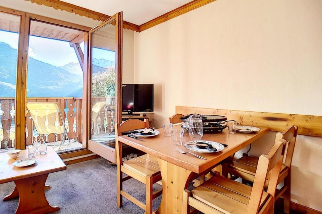 une salle à manger avec une table et une grande fenêtre dans l'établissement Résidence Valmonts A - Appartement classique · Départ ski aux pieds · Balcon MAE-2504, aux Bruyères